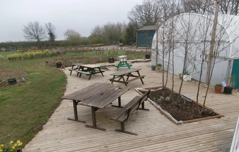 Picture of JHCL facilities showing picnic tables and polytunnel
